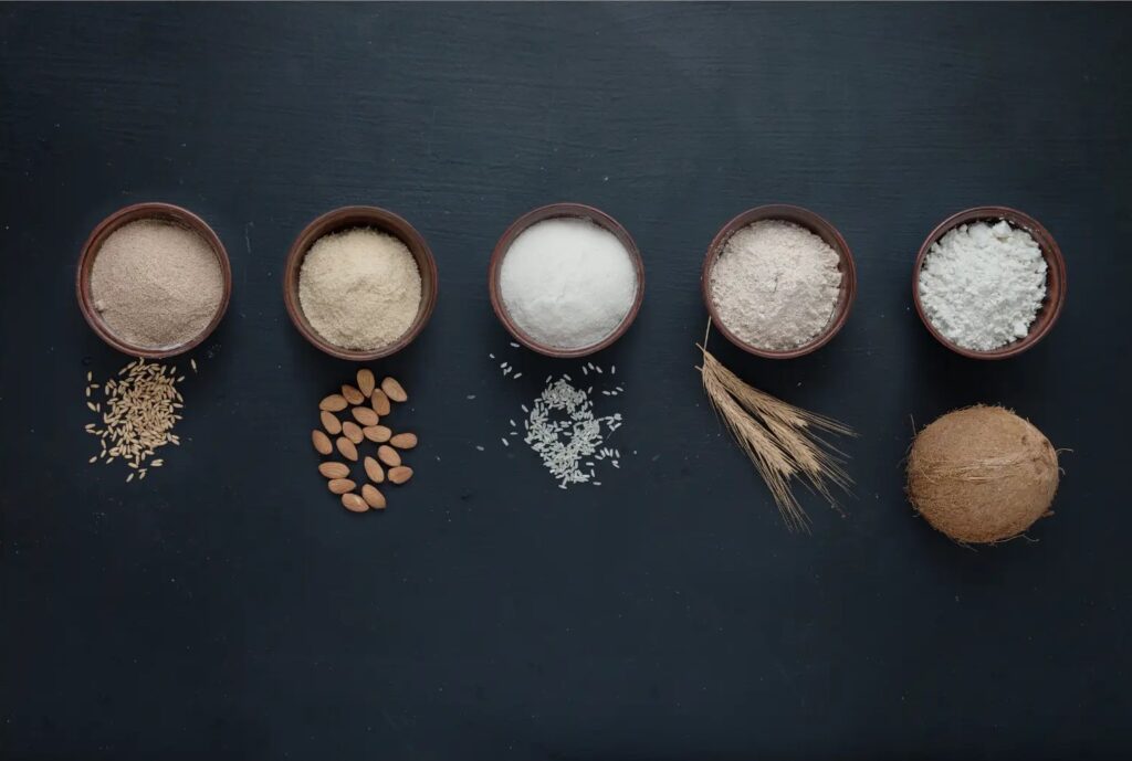 Imagen de varias harinas junto con sus granos, algunas harinas para problemas de intolerancia en las comidas y repostería. preparadas para dulces saludables