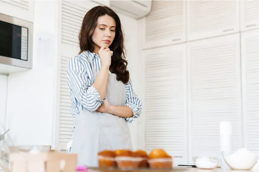 Mujer pensativa en la cocina pensando en hacer  dulces saludables para su familia, no quiere exceso de azúcar y tiene intolerancia a ciertas harinas y a la lactosa